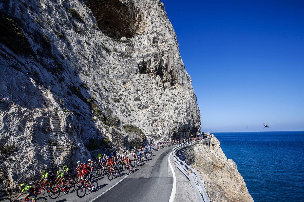 The peloton sweep along the coastal road.