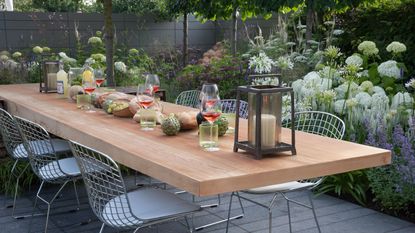outdoor dining space in an urban garden surrounded by a mix of the best plants for small gardens
