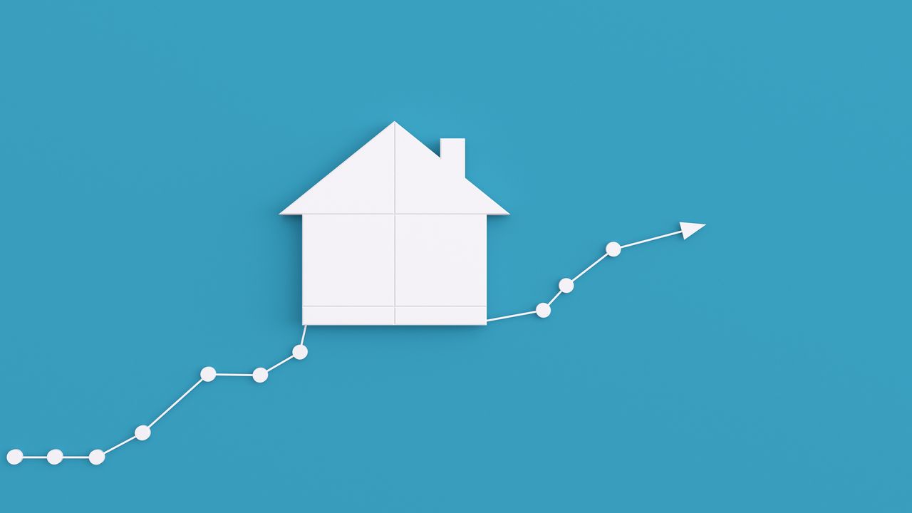 real estate investing concept with white house on top of white moving average and blue background