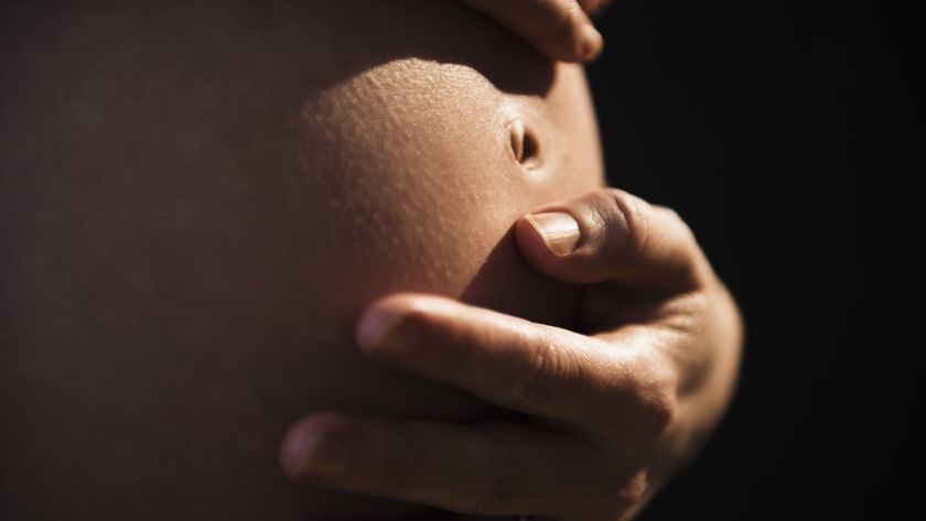 a pregnant woman touches her belly