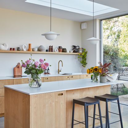 A contemporary, Scandi-style kitchen with pale wooden kitchen cabinets and kitchen island