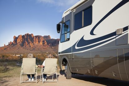 A mature couple outside their RV.