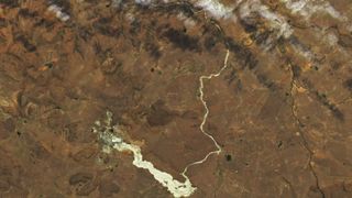 A golden river of dried mud glimmers in this satellite photo taken Oct. 4 by the Landsat 9 satellite. The potentially toxic trail is leftover from a disaster at a diamond mine in Jagesrfontein, South Africa after a dam collapsed.