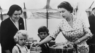 22nd august 1955 queen elizabeth ii with princess anne, prince charles and their nurse, helen lightbody, at a stall during a sale of work event in abergeldie castle, near balmoral castle in aberdeenshire they are raising funds for the building of a new vestry at craithie church photo by fox photosgetty images