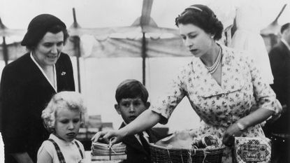 22nd august 1955 queen elizabeth ii with princess anne, prince charles and their nurse, helen lightbody, at a stall during a sale of work event in abergeldie castle, near balmoral castle in aberdeenshire they are raising funds for the building of a new vestry at craithie church photo by fox photosgetty images