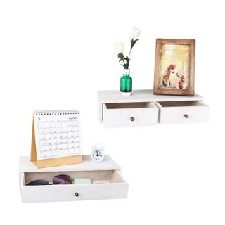 Two white floating shelves with a calendar, vase, and photo frame on