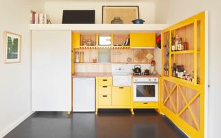 a studio apartment with a fold away kitchen