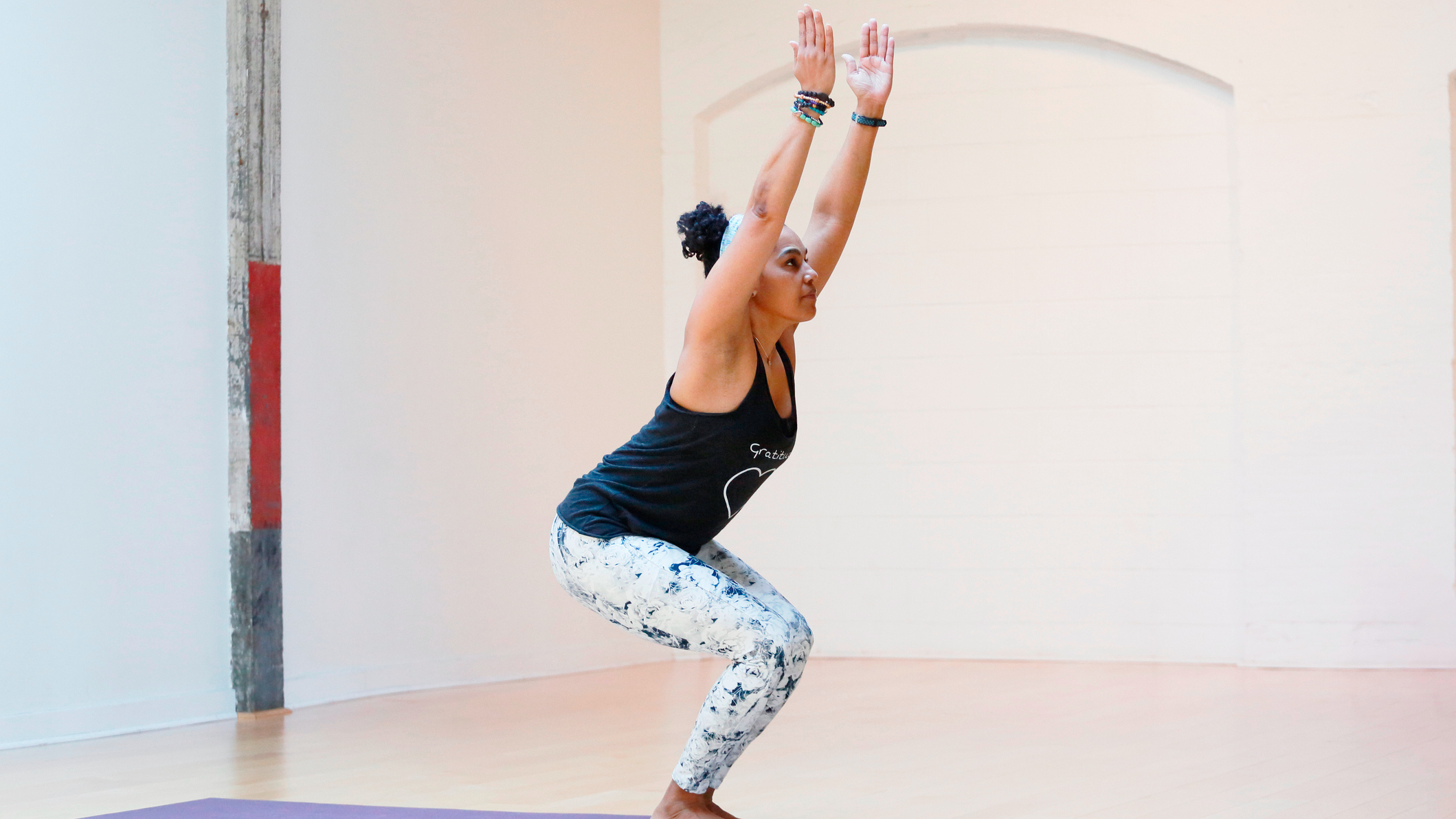 Woman in yoga studio performs chair pose