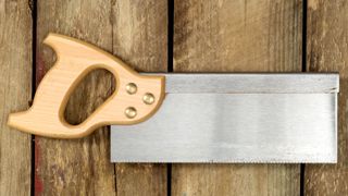 Wooden handled tenon saw laying on wooden background