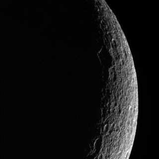 Cassini spacecraft photo of Saturn's moon Rhea hanging in shadow