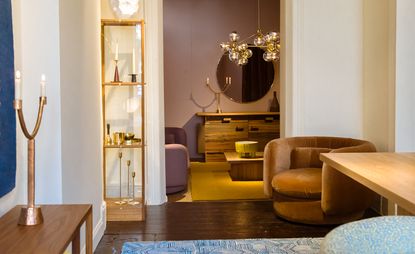 Inside a shop displaying lighting. Dark wood floor, round seating and various light fixtures 