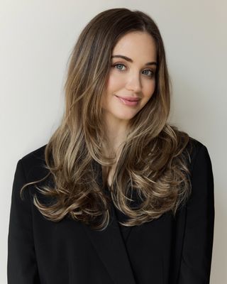 Elizabeth of Stalle Studios in front of a plain backdrop