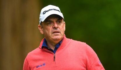 McGinley watches his tee shot in a red jumper