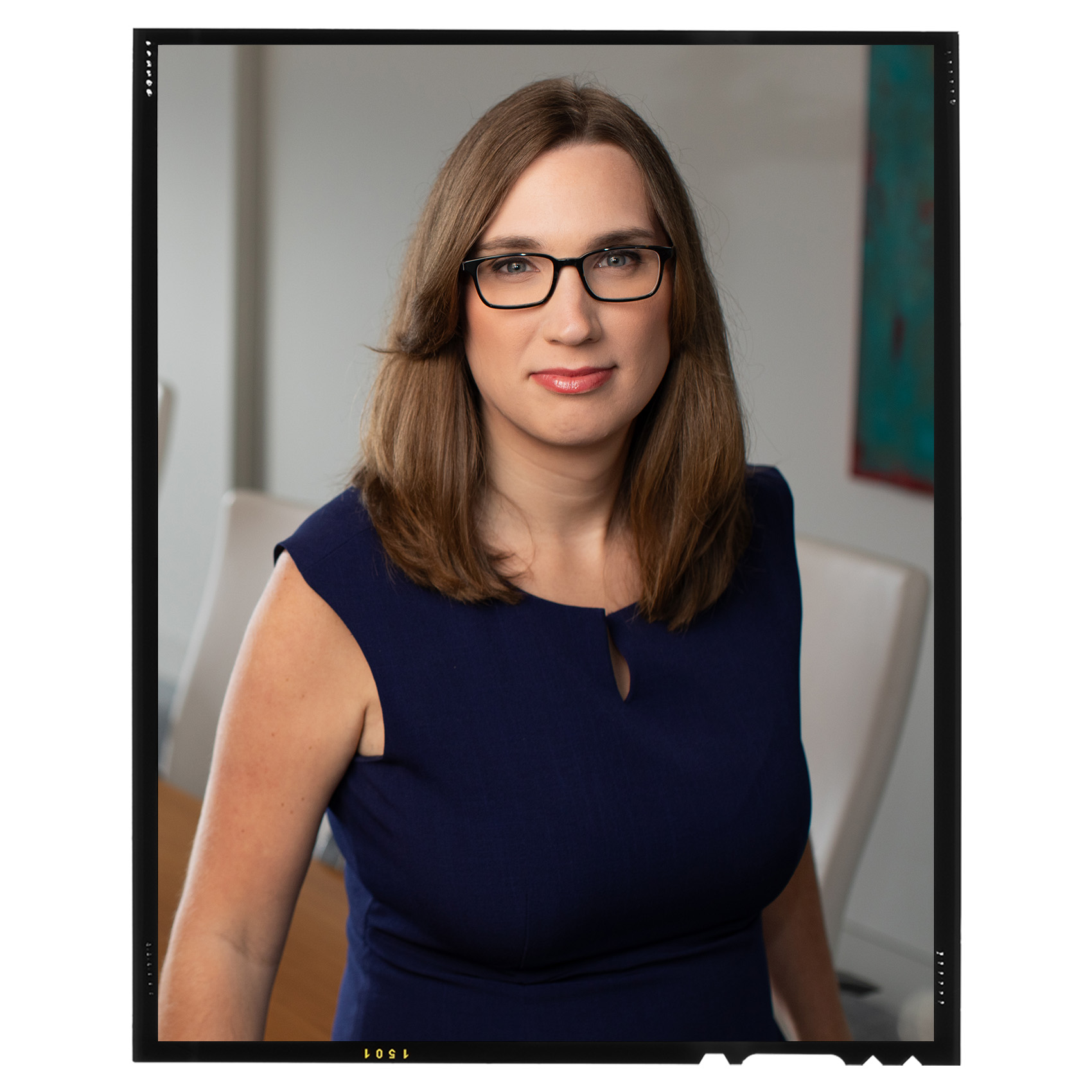 portrait of Rep. Sarah McBride in a blue dress and black glasses