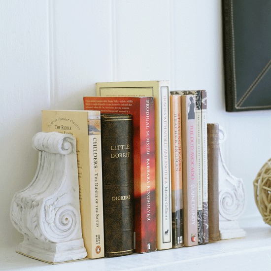 Childrens books against white wall and on top of white book end mantelpiece