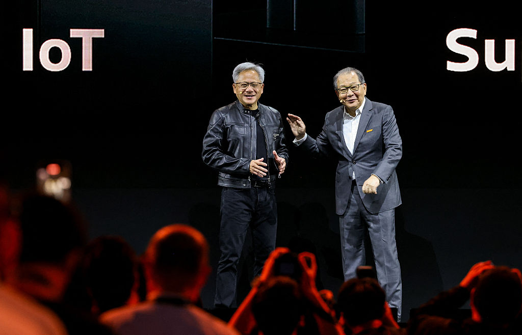 MediaTek CEO Rick Tsai (R) talks with Nvidia CEO Jensen Huang (left) during a keynote speech for Computex 2025 at the Taipei Nangang Exhibition Center Hall in Taipei on May 20, 2025