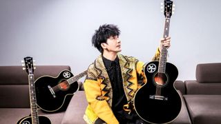 WoWkie Da posing with his signature Inspired by Gibson Custom WoWkie Da J‑180 acoustic