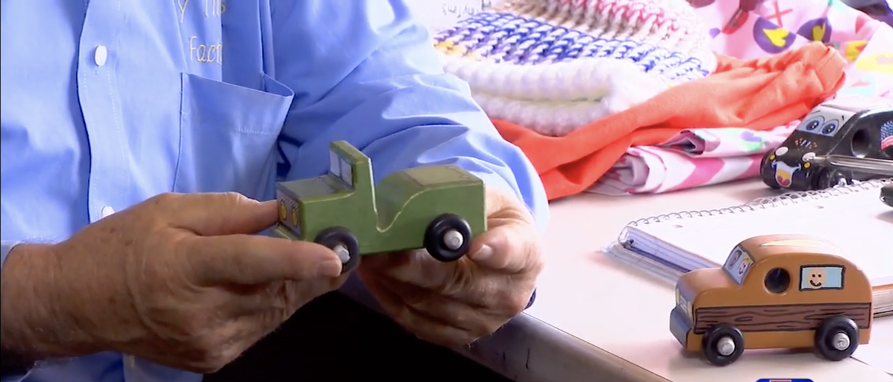 Alton Thacker holds one of the wooden cars he made.