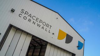 one of the hangars at spaceport Cornwall with large "spaceport Cornwall" letters across the front of the building above the entrance.