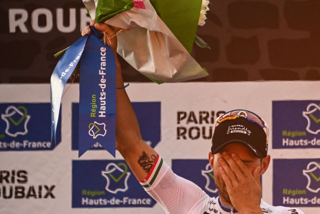 Firstplaced Bahrain Victorious Sonny Colbrelli from Italy celebrates on the podium after competing in the 118th edition of the ParisRoubaix oneday classic cycling race between Compiegne and Roubaix northern France on October 3 2021 Photo by AnneChristine POUJOULAT AFP Photo by ANNECHRISTINE POUJOULATAFP via Getty Images