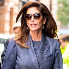 Cindy Crawford wears sunglasses and a gray blazer