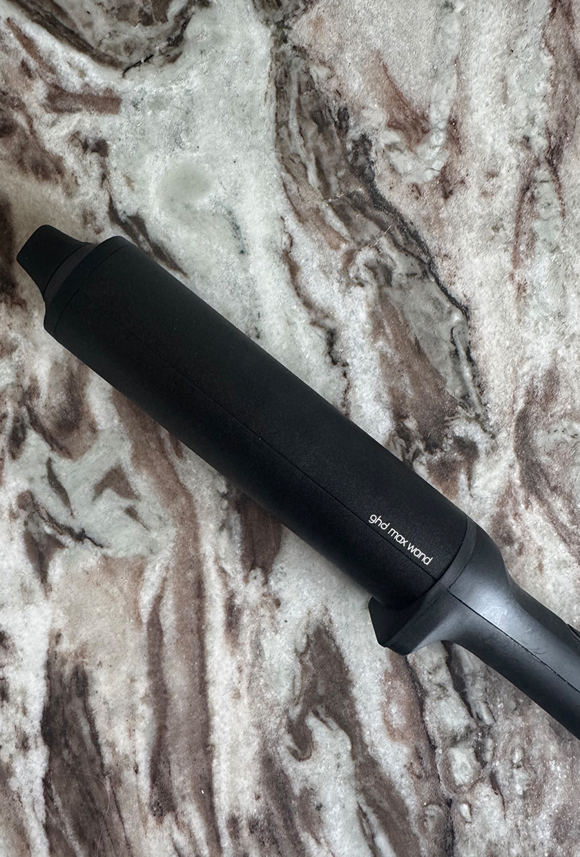 A close up of the curling barrel on the GHD Chronos Curve Max curling wand on marble table