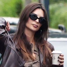 Emily Ratajkowski wearing a leather jacket, plaid shirt, black pants, and Ugg mules in London