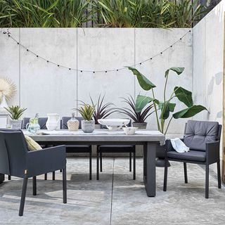 outdoor dining area with dining table with grey chairs