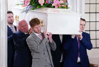 Jay Brown, Ben Mitchell, Phil Mitchell and Callum Highway carrying Lola's white coffin in EastEnders.