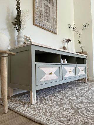 A customised IKEA HEMNES TV unit painted pale green with a geometric pattern