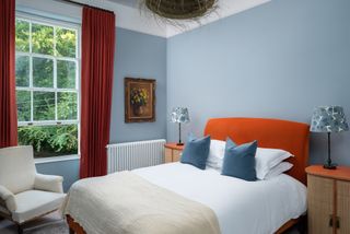 blue bedroom with orange headboard