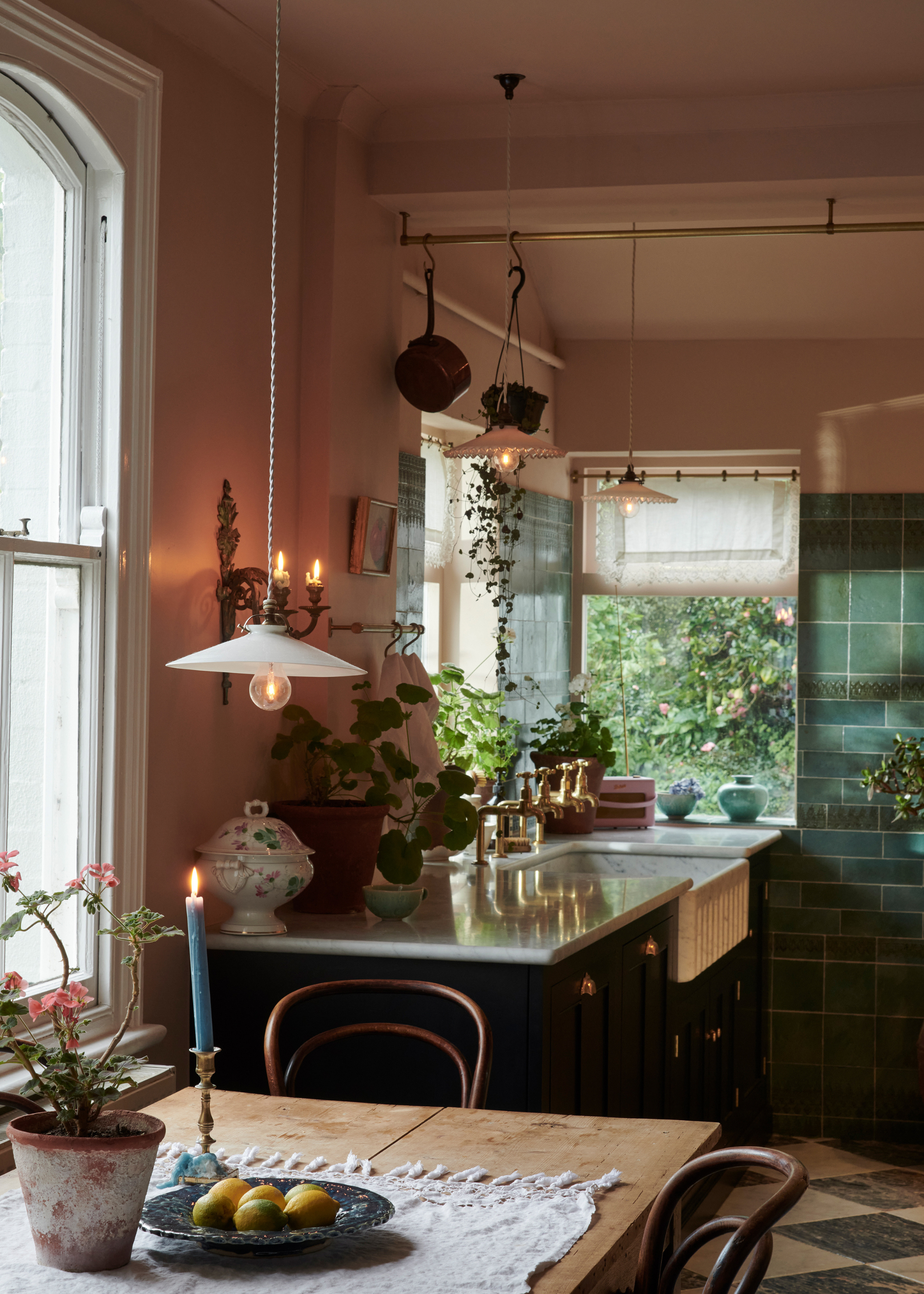 beautiful period home kitchen with pink walls, green tiles and low lighting