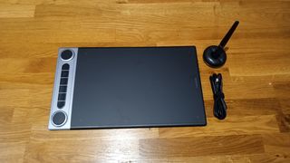 Huion Inspiroy Dial 2 review; a drawing tablet on a wooden table