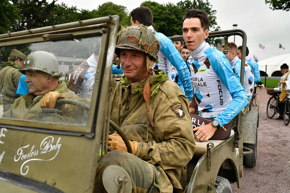 Riders of France's AG2R La Mondiale cycling team, including France's Romain Bardet (R), take part in a parade aboard an World War II US army vehicle during the team presentation ceremony