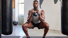 Man performing goblet squat with a kettlebell