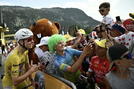 UAE Team Emirates - XRG's Slovenian rider Tadej Pogacar poses for a selfie witch a spectator after the 15th stage of the 113th edition of the Tour de France cycling race, 183,9 km between Champagnole and Plateau de Solaison in the Jura mountains, on July 19, 2026. (Photo by Loic VENANCE / AFP)