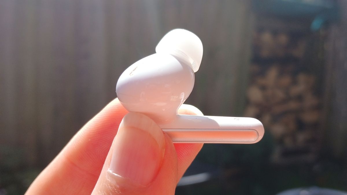 The Soundcore Liberty 5 earbuds outside in the sunlight and held by our reviewer, Katie Wickens.