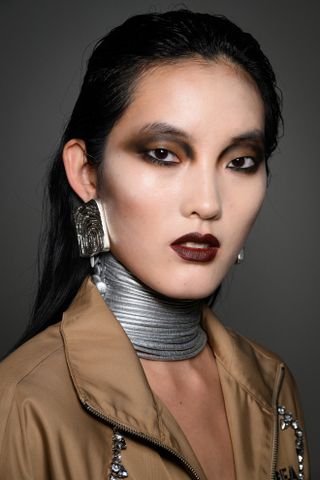 a model at area at new york fashion week wearing a choker necklace and vampy makeup