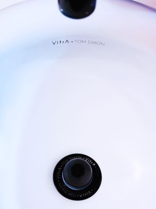 Detail of white sink, with the words VitrA x Tom Dixon printed inside in black type