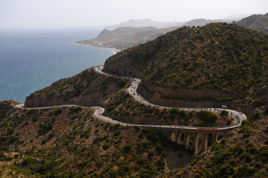 CABO DE GATA SPAIN AUGUST 31 A general view of the peloton passing across a bridge in a landscape during the 77th Tour of Spain 2022 Stage 11 a 1912km stage from ElPozo Alimentacin Alhama de Murcia to Cabo de Gata LaVuelta22 WorldTour on August 31 2022 in Cabo de Gata Spain Photo by Justin SetterfieldGetty Images