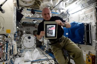 Scott Kelly displays the cover of Tom Wolfe's "The Right Stuff" on his iPad aboard the International Space Station in 2016.
