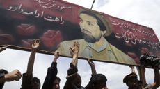 Afghans protest under an image of the late Ahmad Shah Massoud in Kabul in 2003