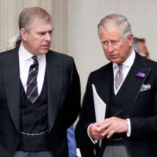 Prince Andrew talking to King Charles, both in dark suits