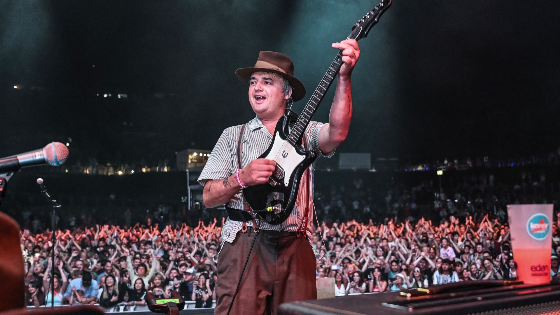 an image of The Libertine's frontman Pete Doherty playing electric guitar in front of a huge crowd