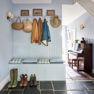 pale blue painted farmhouse hallway with bench seat, peg rail for coats above and a piano