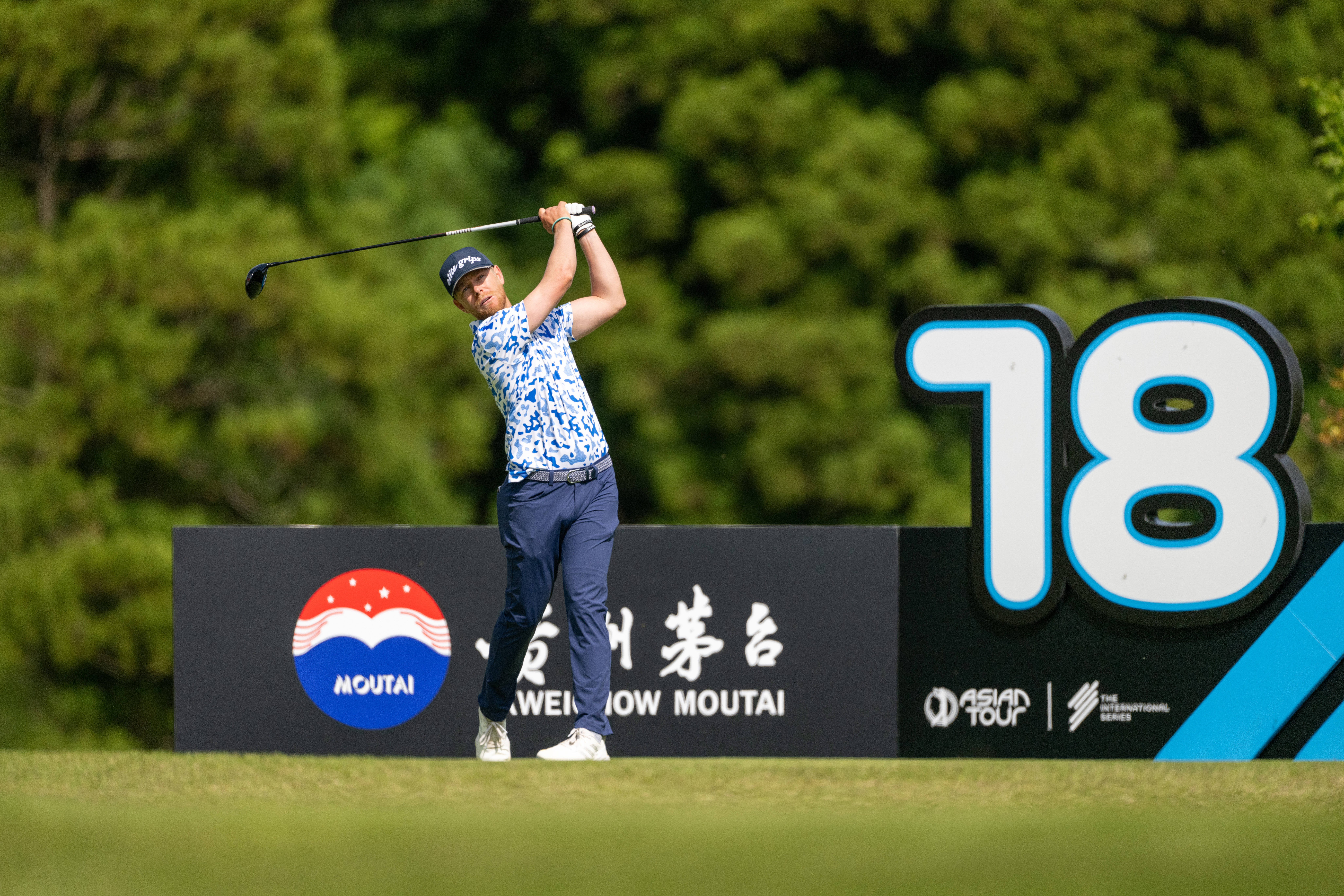 Scott Vincent hits a tee shot in front of a tee marker
