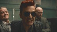 Crowley sneering and gritting his teeth with his arms held behind him in Good Omens Season 3