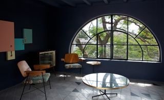 Chairs and coffee table facing semi-circlular window