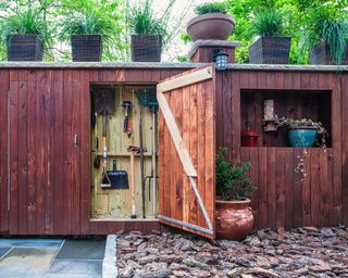 A narrow garden shed in a side yard
