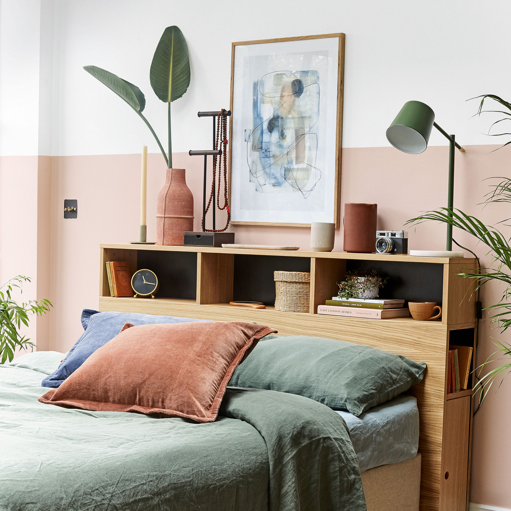 Pink bedroom with storage headboard and green bedding